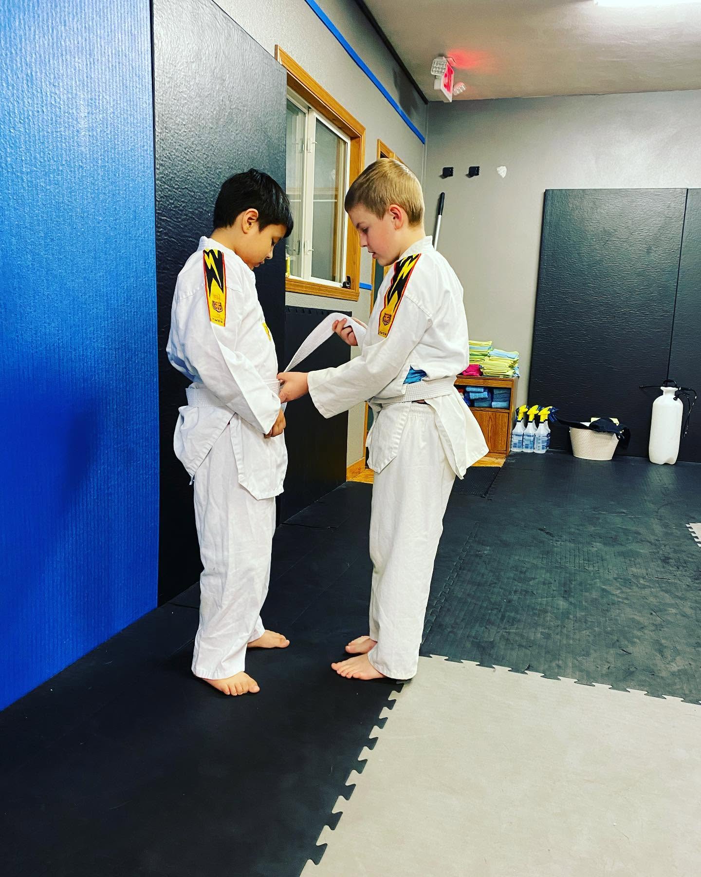 Young Taekwondo students tying belts