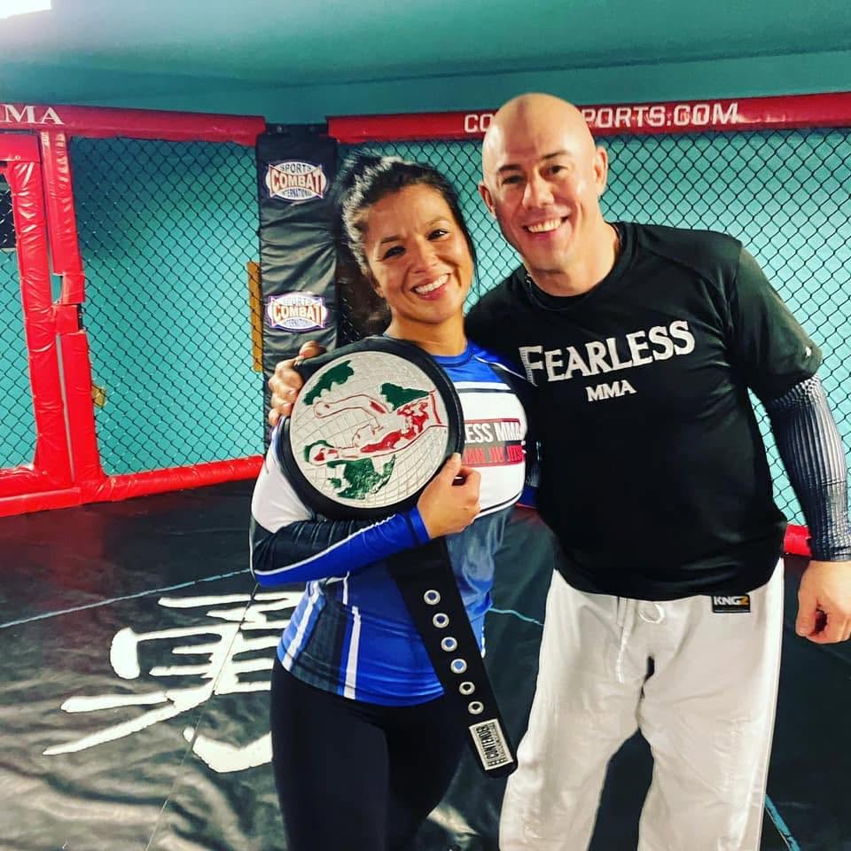 Coach and student with jiu-jitsu championship belt